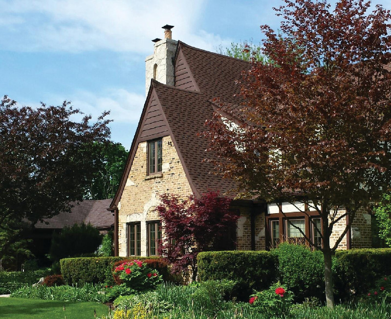 English tudor home in Chicago home with dark brown roof and spacious garden